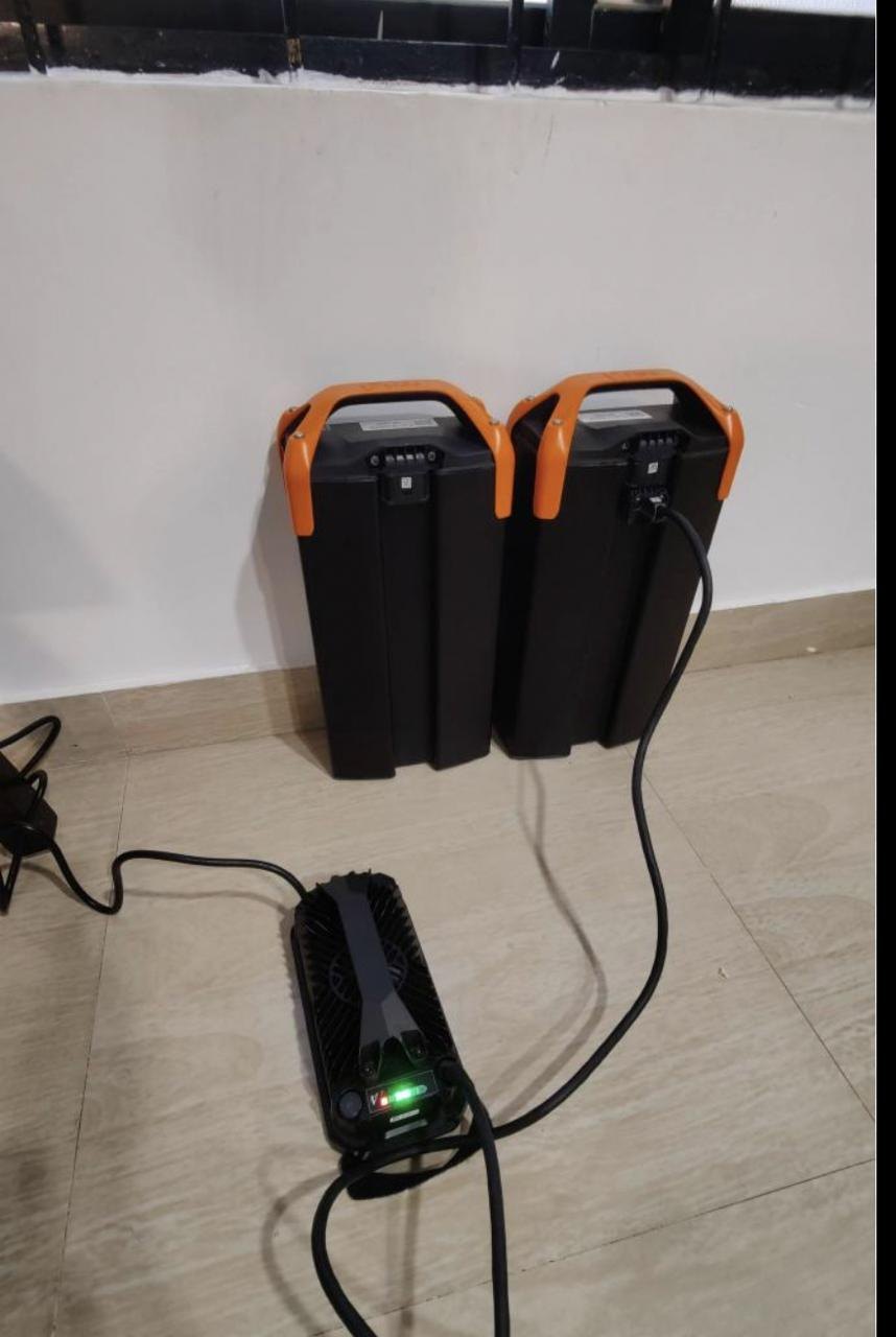Two removable EV scooter battery packs charging at home